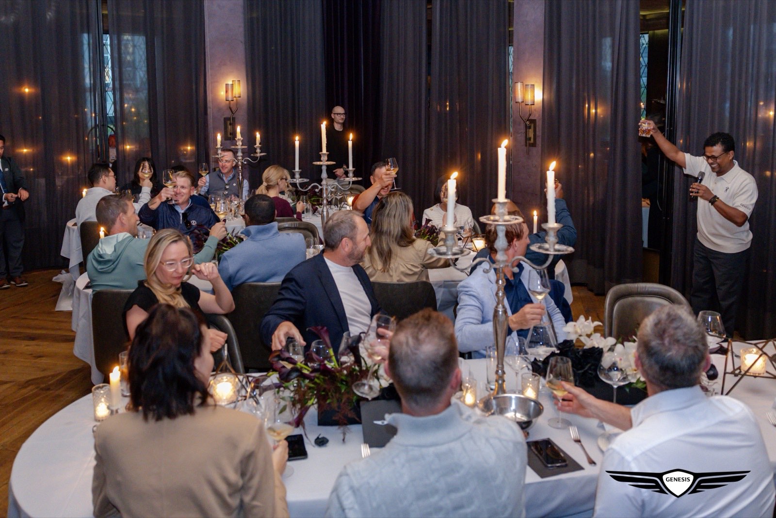 Genesis Presidents Cup guests seated along a long candlelit dinner table