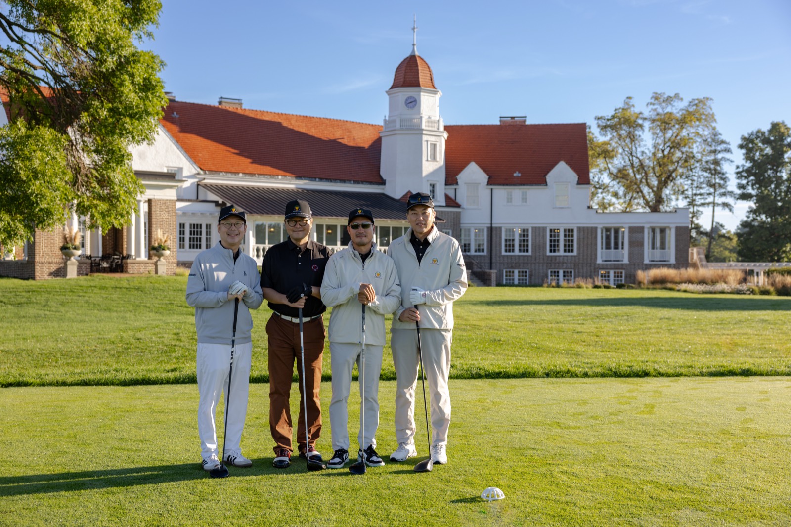 A Genesis foursome on the tee in front of the Chicago Golf Club clubhouse
