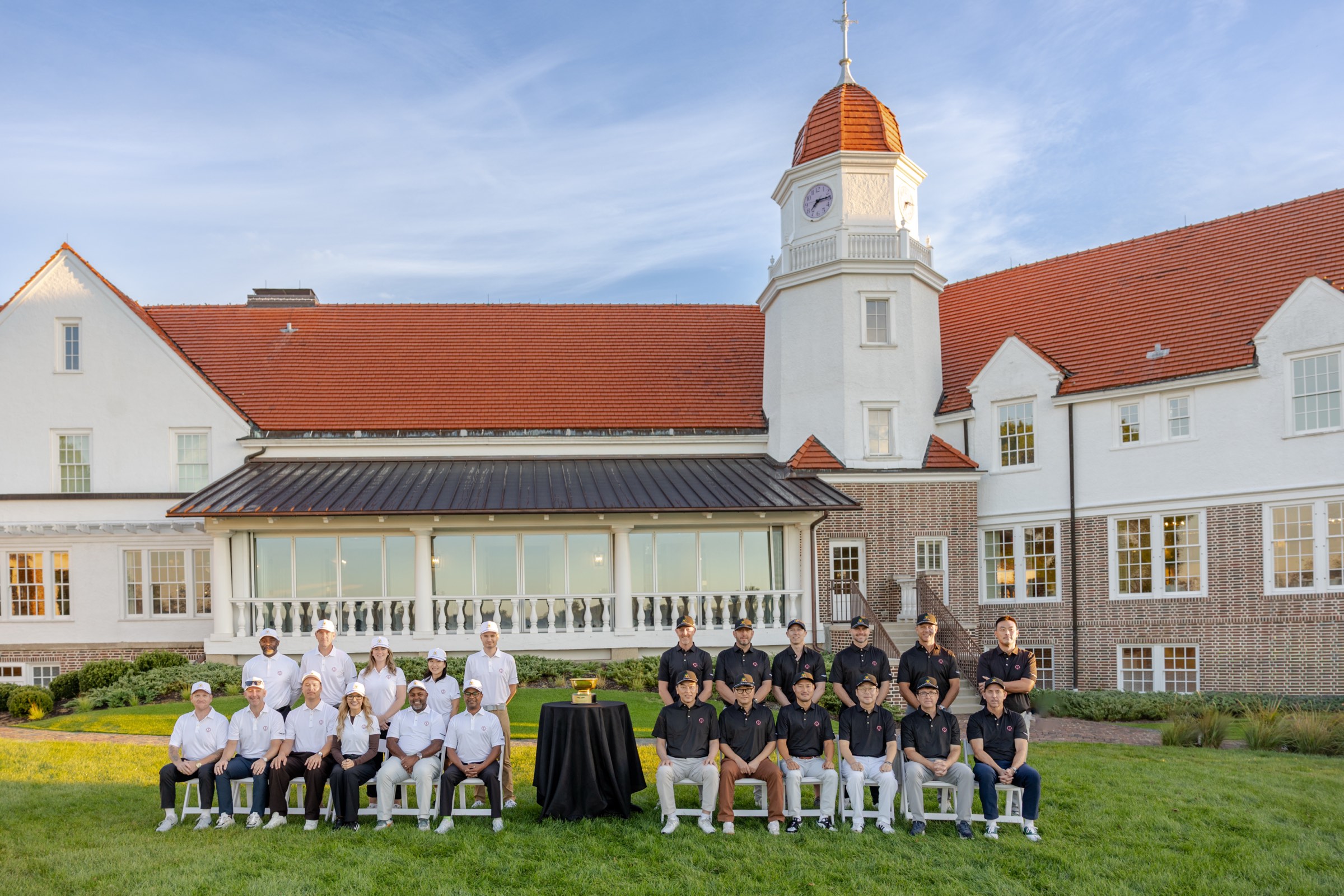 The Genesis Presidents Cup group with the trophy in front of the Chicago Golf Club clubhouse