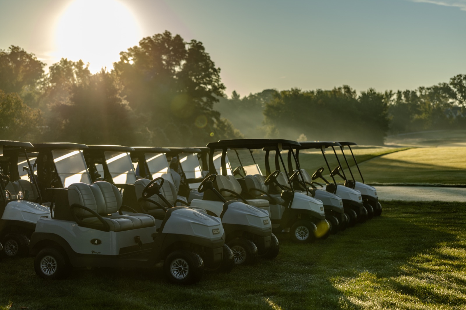 A row of golf carts on the grass at sunrise at Chicago Golf Club
