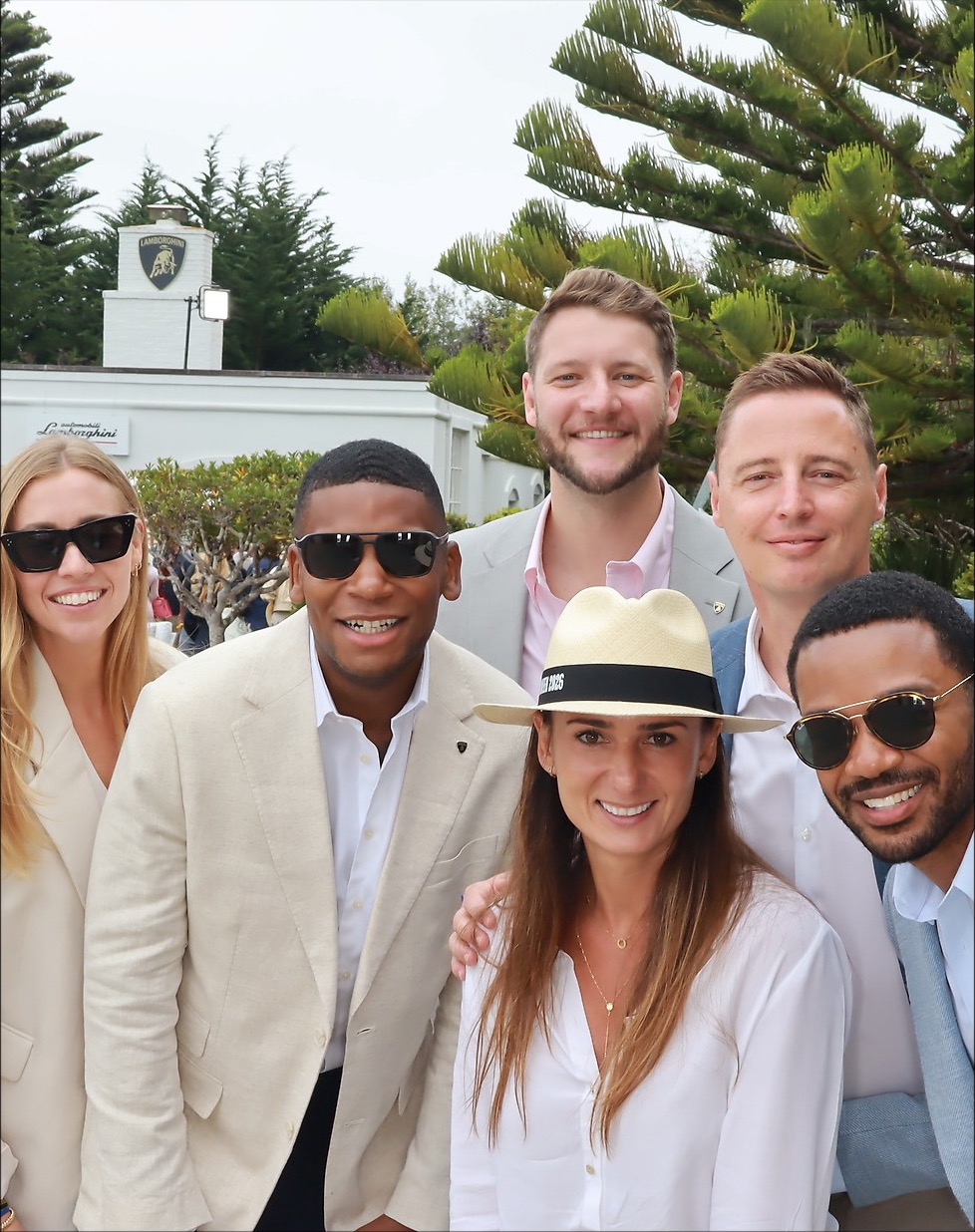 6 guests smiling for a group photo outside Lamborghini Villa during Monterey Car Week 2026