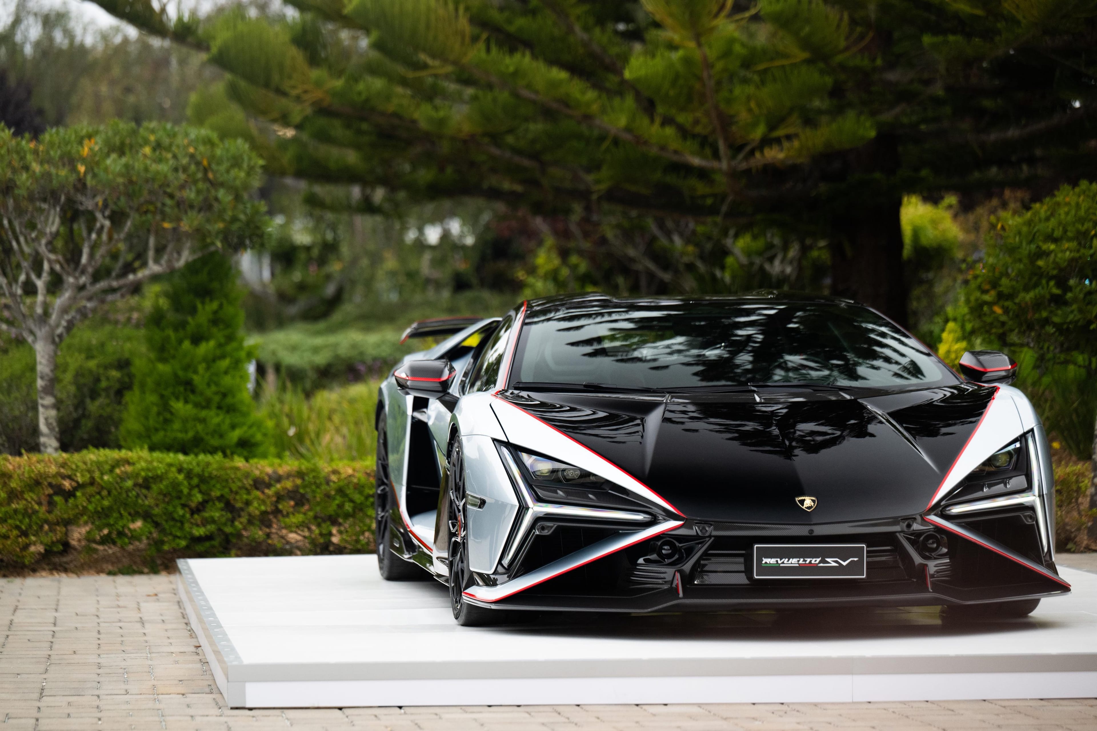 Lamborghini Revuelto SV displayed in a garden setting at Monterey Car Week