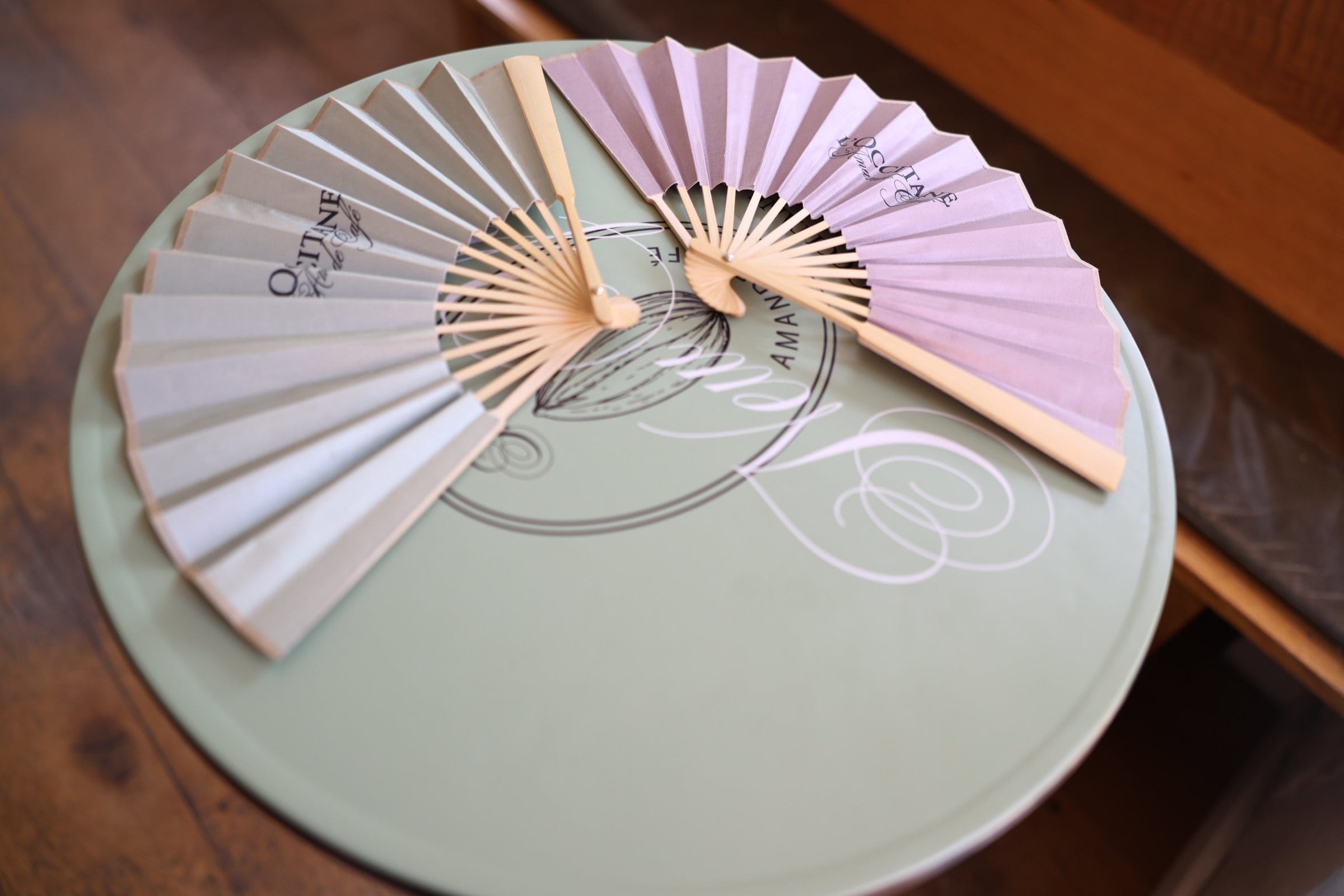 L'OCCITANE Amande Cafe branded fans on a table