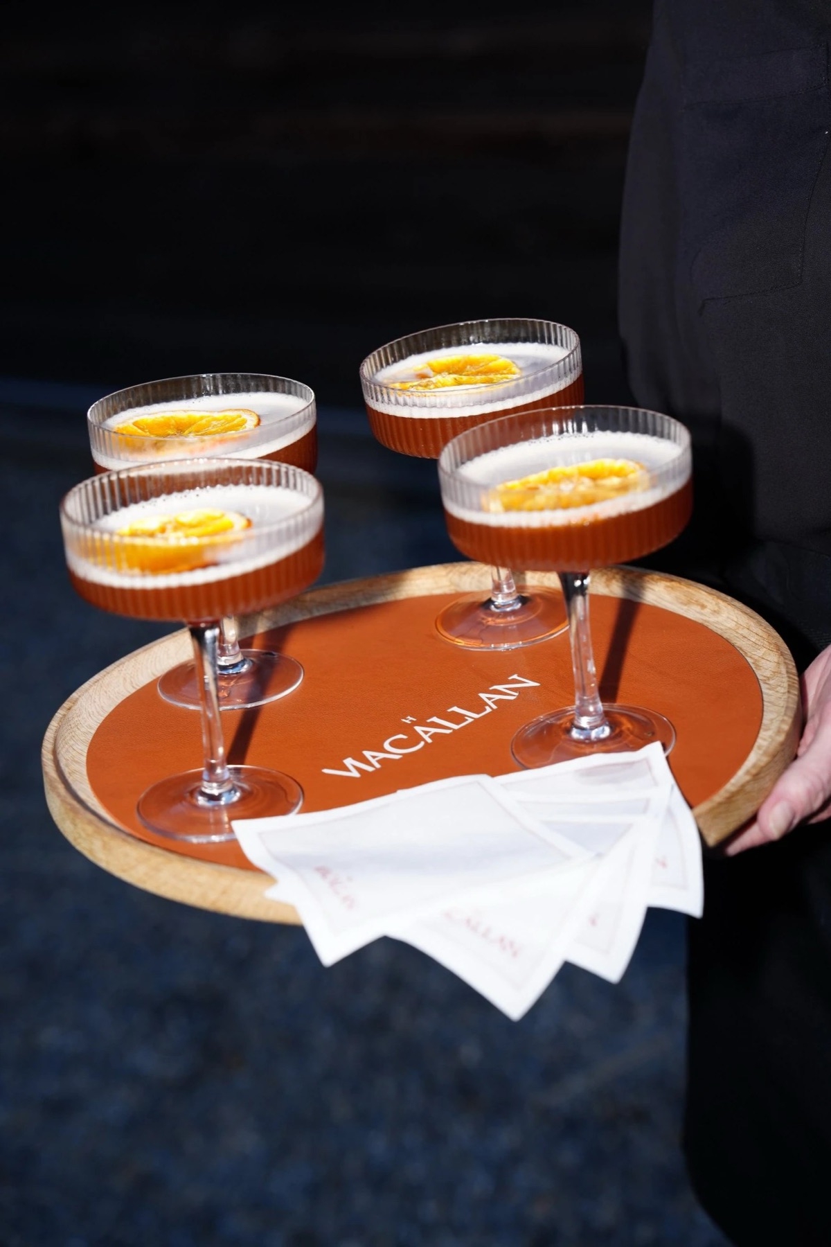 Four cocktails with dried orange on a The Macallan serving tray