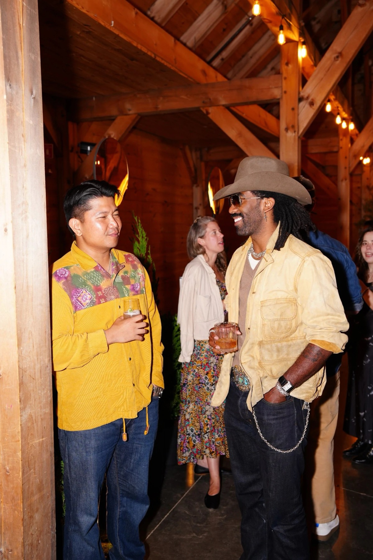 Two guests talking over drinks in the barn at INNESS