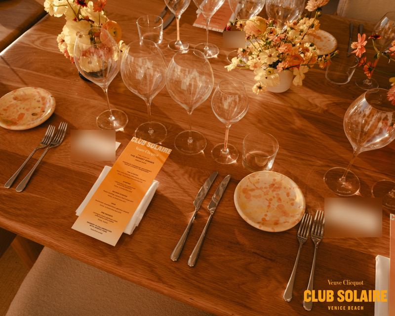 A Club Solaire place setting with a printed menu and wine glasses