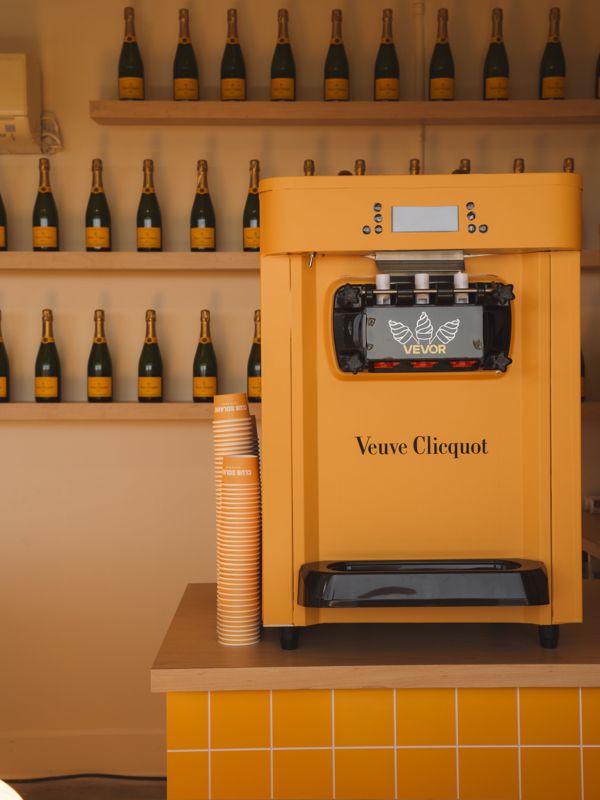 A Veuve Clicquot soft serve machine in front of shelves of champagne