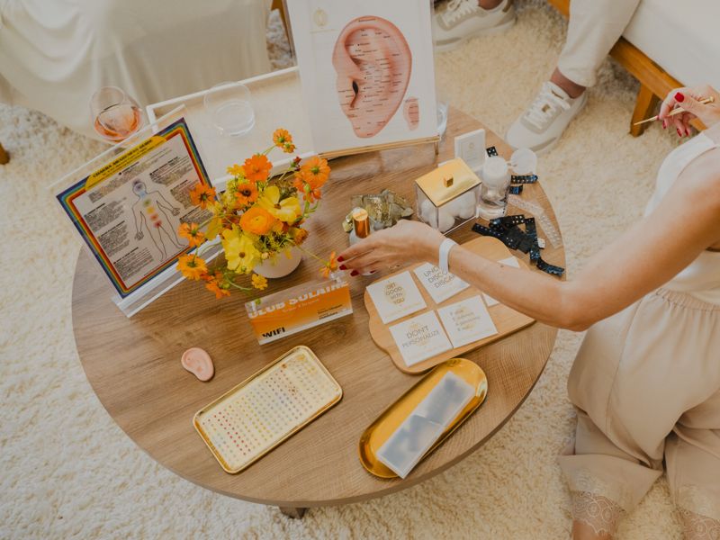 A guest at a Sunset Party activity table with flowers and Club Solaire cards