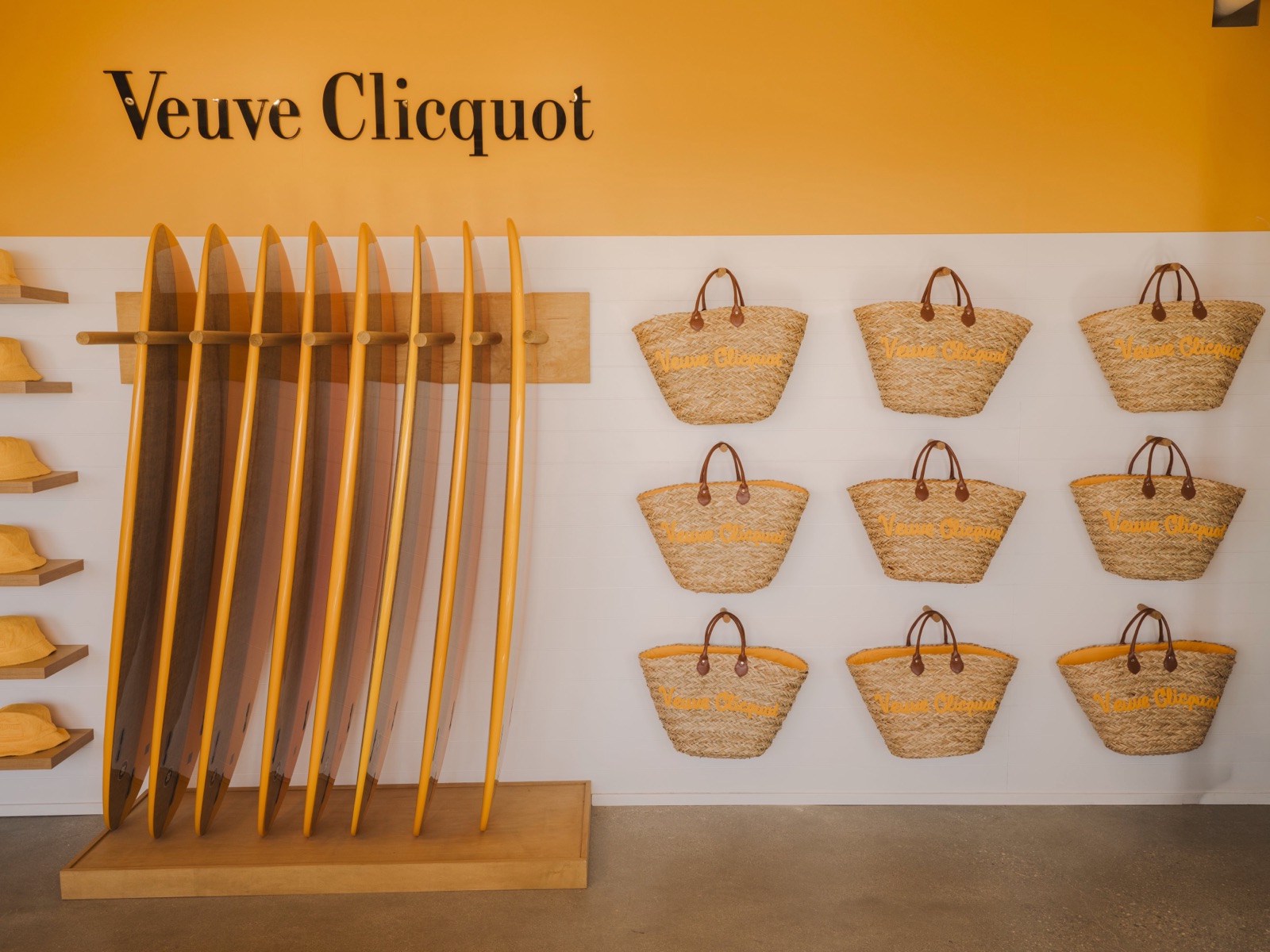A wall of Veuve Clicquot branded beach baskets and surfboards at Club Solaire