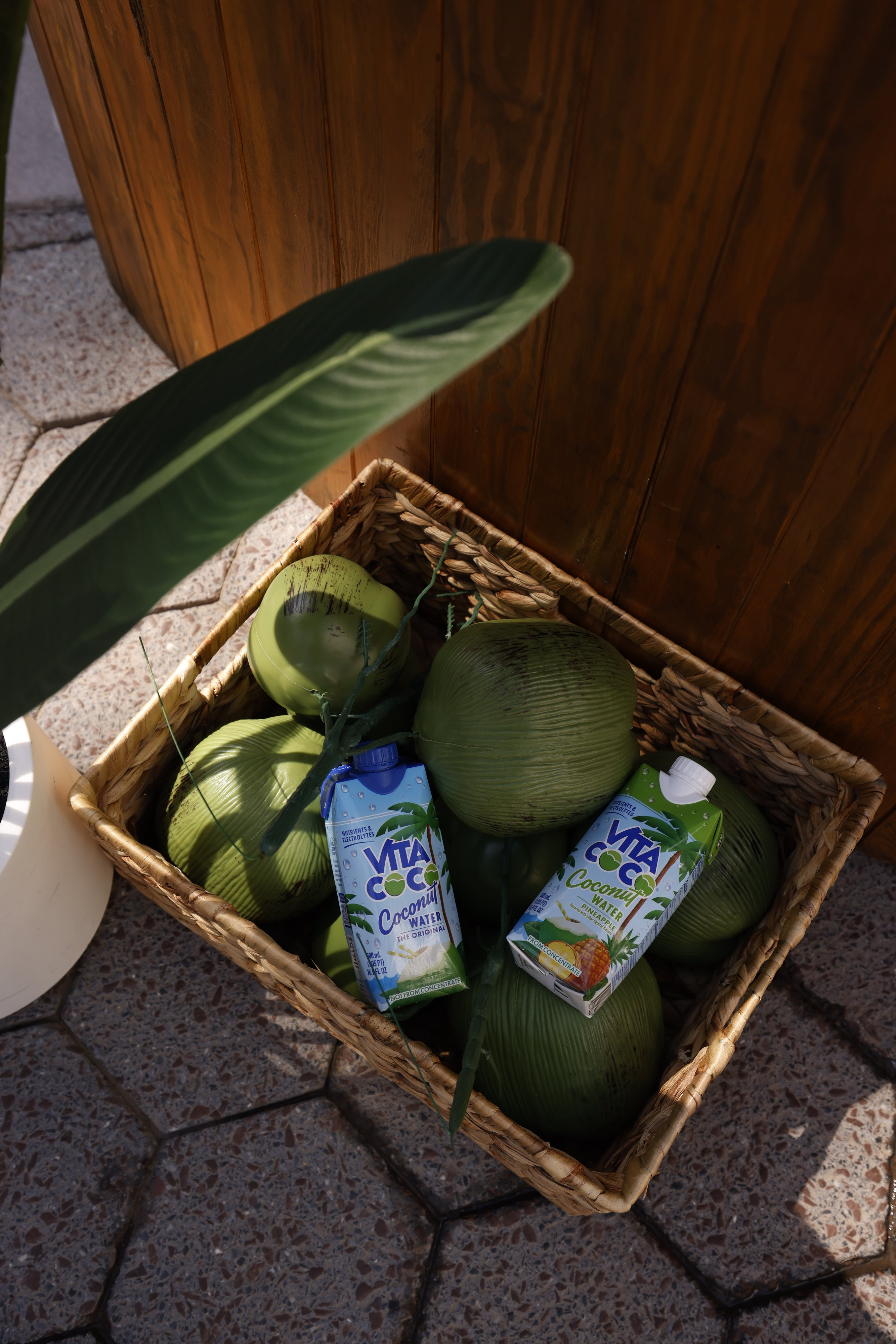 Vita Coco cartons displayed with coconuts in a basket