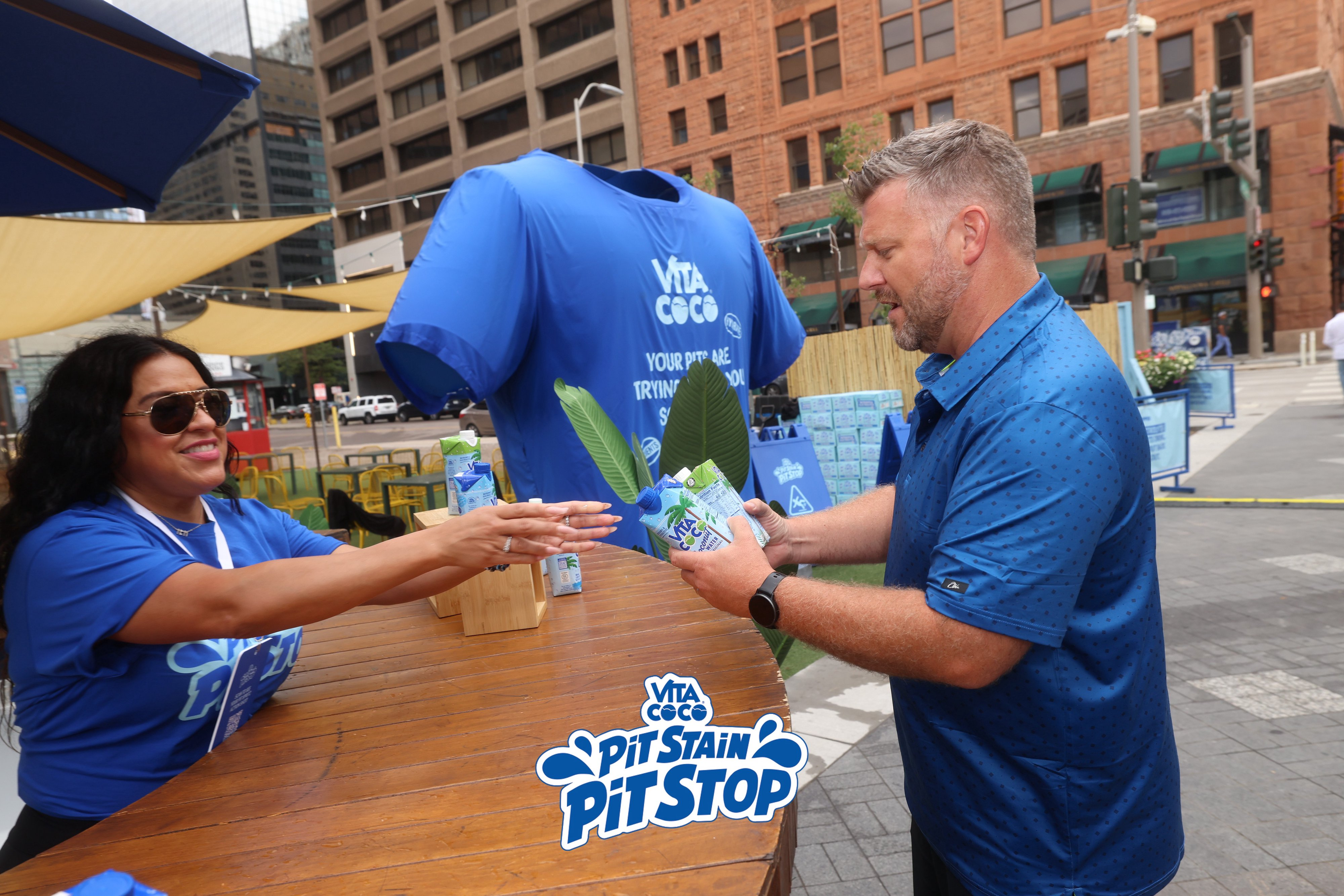 A Vita Coco brand ambassador handing samples to a guest at the tour stop