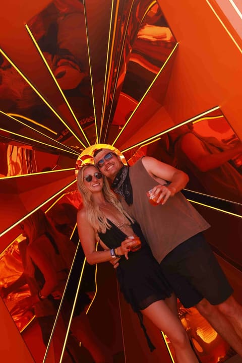 Two guests posing in the Aperol space at Coachella